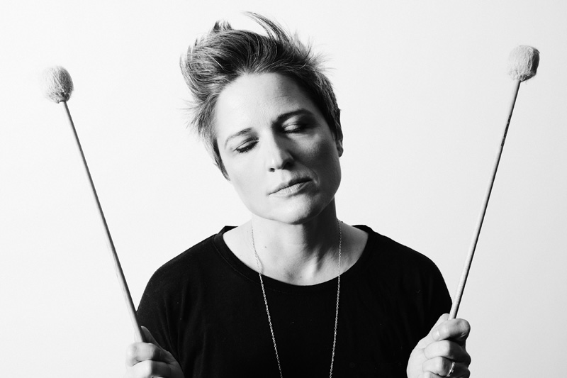 Allison Miller eyes closed, in dreamy way, holding percussion mallets.